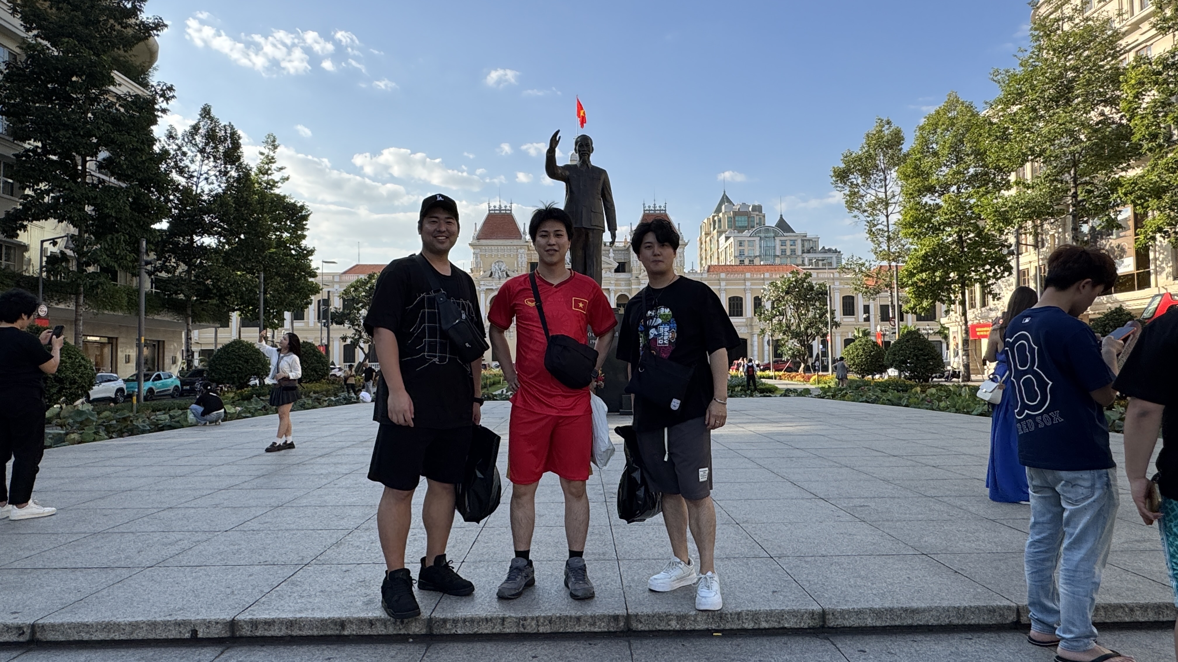 ホーチミン像前で代表の福田、取締役の島田、大川の3名が記念撮影している様子